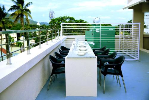 balkon ze stołem i krzesłami w budynku w obiekcie Vismaya Comforts w mieście Mysuru