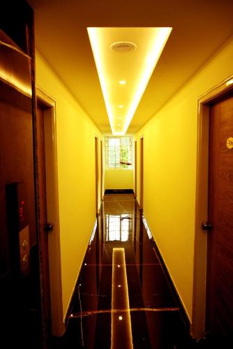 an empty hallway with yellow walls and a ceiling at Vismaya Comforts in Mysore