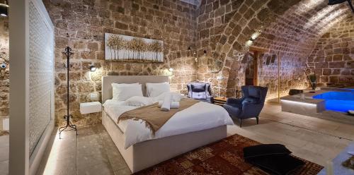 a bedroom with a bed and a bathroom with a tub at Dalaa in ‘Akko
