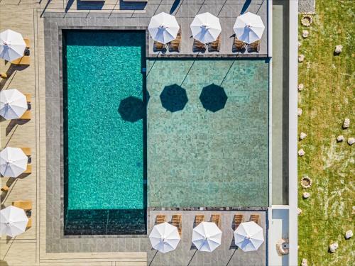 an overhead view of a swimming pool with umbrellas at One Suite THE GRAND in Nakijin