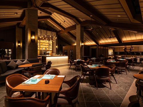 a restaurant with tables and chairs and a bar at One Suite THE GRAND in Nakijin