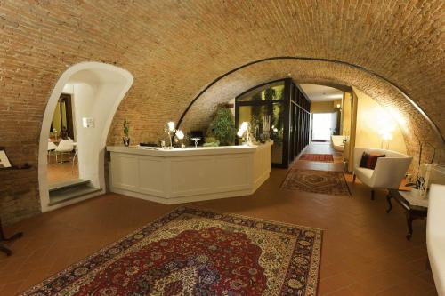ein Wohnzimmer mit einem Torbogen in einem Gebäude mit einem Teppich in der Unterkunft Hotel San Miniato in San Miniato