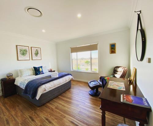 a bedroom with a bed and a desk and a table at The Mains Guest House 2 Bedroom Farm Stay in Corrigin