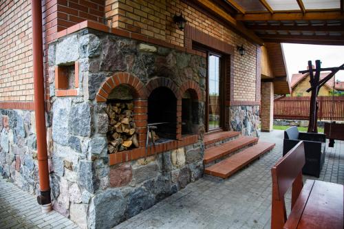 a large brick oven in a patio with a wooden bench at Leśne zacisze- rowery,łódka,kajak in Kallinowen