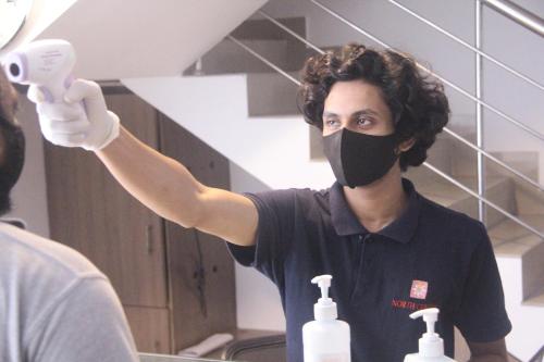 a man wearing a mask holding a bottle of soap at North Centre in Cochin