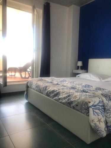 a bedroom with a bed with a blue wall and a window at Marina di VASTO in Vasto