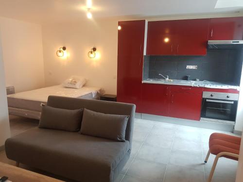 Pokój z kanapą i kuchnią z czerwonymi szafkami w obiekcie Studio 30 m2 toutlemonde w mieście Toutlemonde