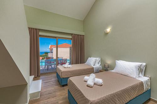 a hotel room with two beds and a balcony at Kozanos Hotel & Suites in Amoudi