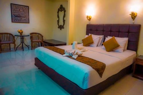um quarto com uma cama grande num quarto em Mandala Wisata Hotel em Surakarta