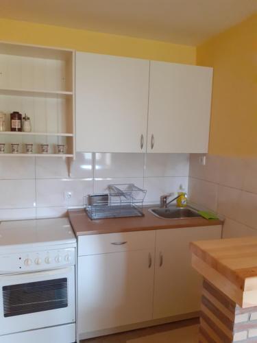 a kitchen with white cabinets and a sink at Apartman Mijovic - Nova Varos in Nova Varoš