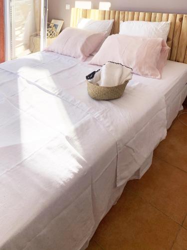 - un lit blanc avec un panier dans l'établissement MIKA DE MACHJA, à Propriano