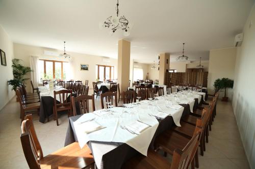 una grande sala da pranzo con tavoli e sedie lunghi di La Collina dei Goti Agriturismo ,Azienda Agricola a Cerreta