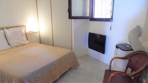 une chambre avec un lit, une chaise et une télévision dans l'établissement CANNES plage 2mn/45m2/vue mer/inernet/clim/parking privé, à Cannes