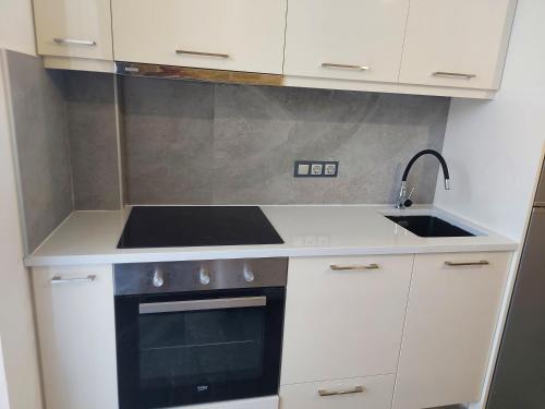 a white kitchen with a sink and a stove at The Santo George Beach Resort in Amoudara Herakliou