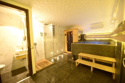 a bathroom with a tub and a bench and a shower at Vila Dijana - Avala in Belgrade