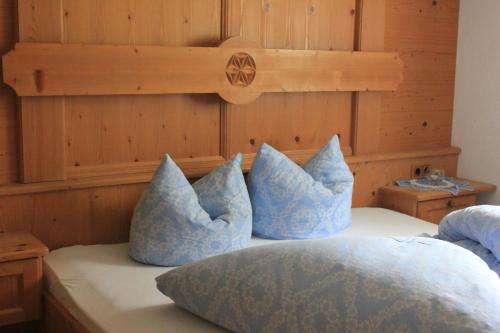 a bed with blue pillows on top of it at Appartement Huber in Pertisau