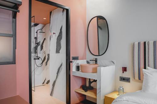 a bathroom with a shower and a sink and a mirror at Pavo Art Hotel in Heraklio Town
