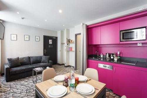 un soggiorno con un tavolo e un divano di Serotel Suites Opera a Parigi