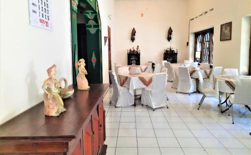 KlatenにあるHotel Perdanaの白いテーブルと白い椅子が備わるレストラン