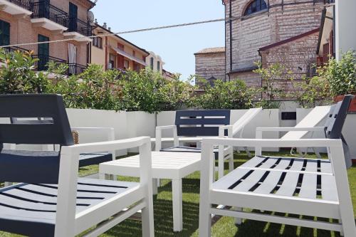 a group of white chairs sitting on a patio at Hotel Enzo in Porto Recanati