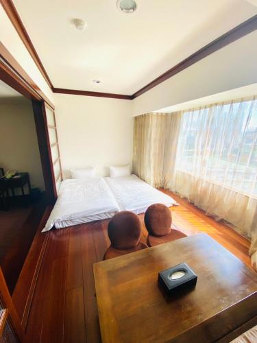 a bedroom with a bed and two people sitting on the floor at Beautiful Hotel Taipei in Xindian