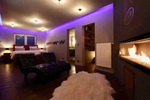 Schlafzimmer mit violetter Beleuchtung, einem Bett und einem Teppich in der Unterkunft El nido Malaika-Villa privative in Monts