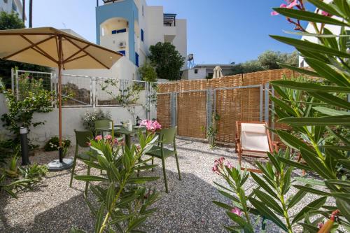 a patio with a table and chairs and an umbrella at Eleana Nature & Art in Khóra Sfakíon