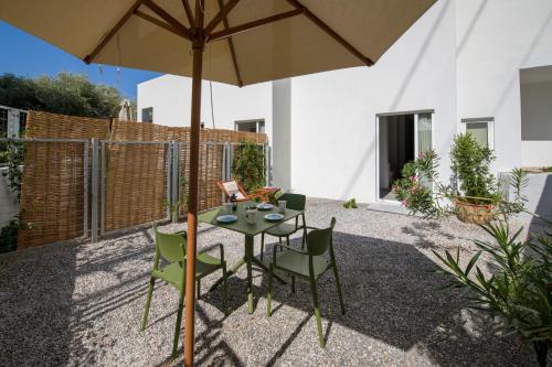 a patio with a table and chairs and an umbrella at Eleana Nature & Art in Khóra Sfakíon