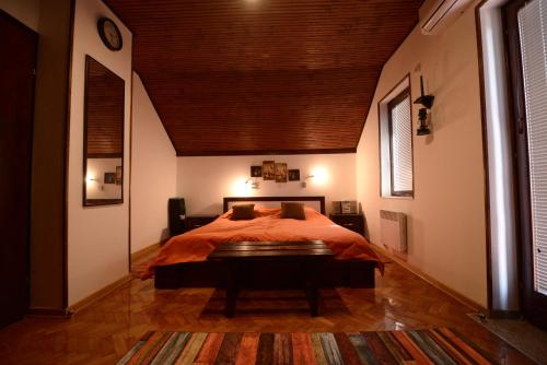 a bedroom with a bed and a wooden ceiling at Villa Dijana - Pool, Spa, Outdoor Kitchen in Belgrade