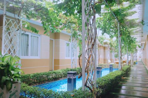 a courtyard of a building with a swimming pool and trees at Sao Vang Hotel in Bao Loc