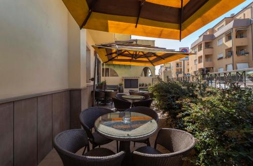 a patio with tables and chairs on a balcony at Hotel San Giuan in Alghero