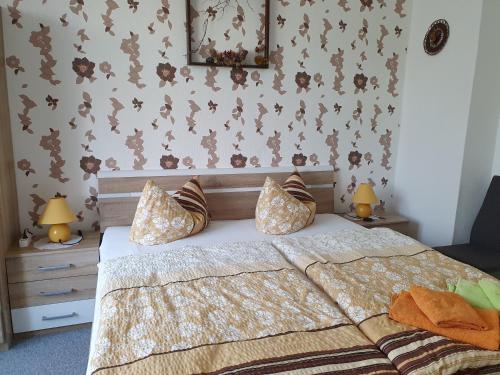 a bedroom with a large bed with two lamps at Pension Edelweiß in Kurort Gohrisch