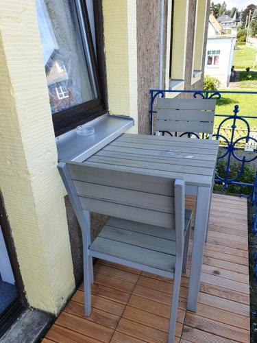 a wooden table sitting on a porch next to a window at Pension Edelweiß in Kurort Gohrisch