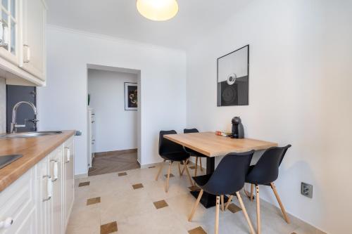 a kitchen and dining room with a wooden table and chairs at Urbio Private Suites in Cluj-Napoca