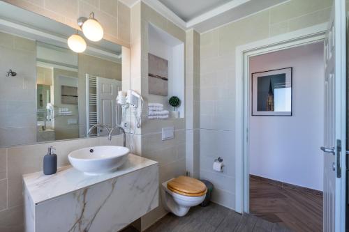 a white bathroom with a sink and a toilet at Urbio Private Suites in Cluj-Napoca
