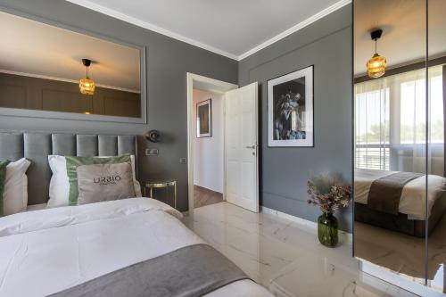 a bedroom with a large white bed and a mirror at Urbio Private Suites in Cluj-Napoca