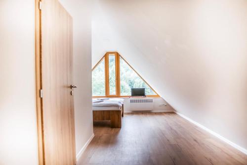 an attic bedroom with a bed and a window at Penzion a Restaurace v Zátiší in Horní Lhota