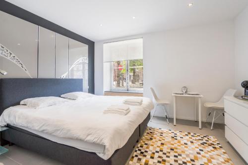 een slaapkamer met een groot bed en een tafel bij Modern guest house in centre of Bruges in Brugge