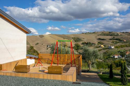 a playground on a deck with a hill in the background at Casa Dolce Casa - Casa Vacanze in Ariano Irpino
