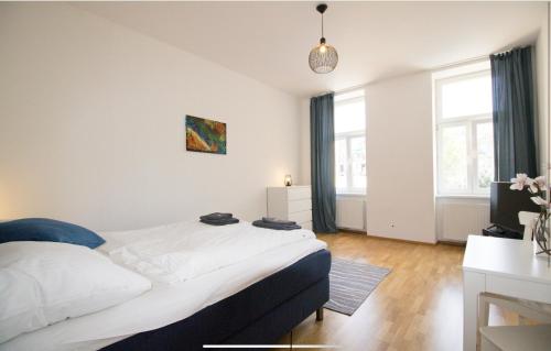 a bedroom with a large white bed and two windows at Gelassener Aufenthalt l LF9 in Vienna