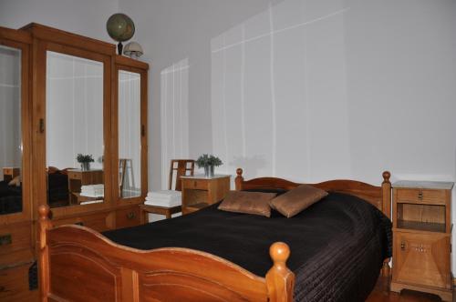 - une chambre avec un lit en bois et un miroir dans l'établissement Apartament Sopot Andre, à Sopot