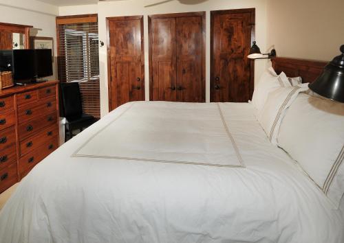 a bedroom with a white bed and a television at Lionshead Center #201 Condo in Vail