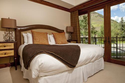 a bedroom with a large bed and a balcony at Ritz Carlton Residence Vail #112 Condo in Vail