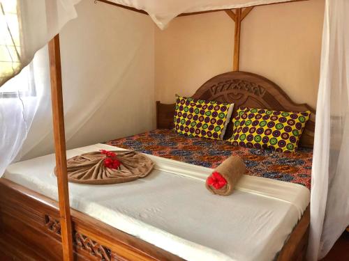 a bedroom with a bed with two pillows and a canopy at Magharibi House in Nungwi