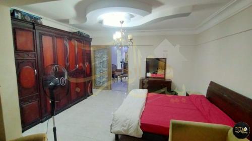 um quarto com uma cama vermelha e uma cómoda em شقة للإيجار اليومي أمام عمارات المحروسة لا ترى البحر 7 em Alexandria