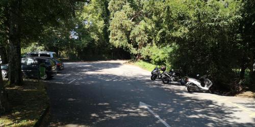 un groupe de motocycles garés sur une route arborée dans l'établissement John Knox International Center, à Genève