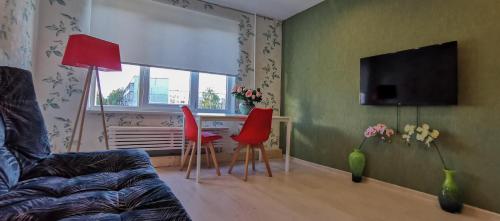 a living room with a couch and a table and chairs at Nameja Apartments in Jēkabpils