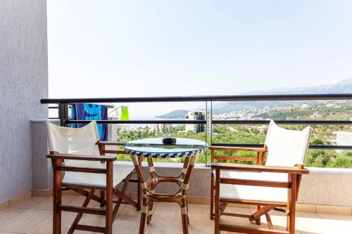 a balcony with a table and chairs and a view at Toni Retzo Rooms in Himare