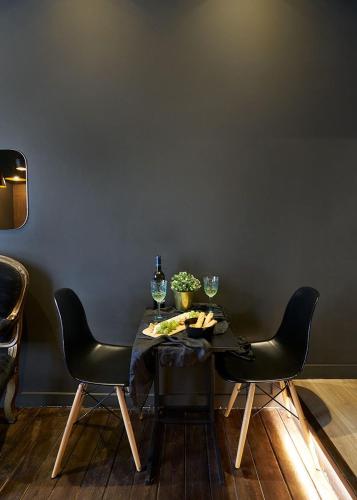 a table with two chairs and wine glasses on it at Urban Suite Santander in Santander