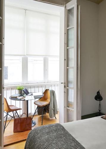 a bedroom with a bed and a desk and a window at Urban Suite Santander in Santander